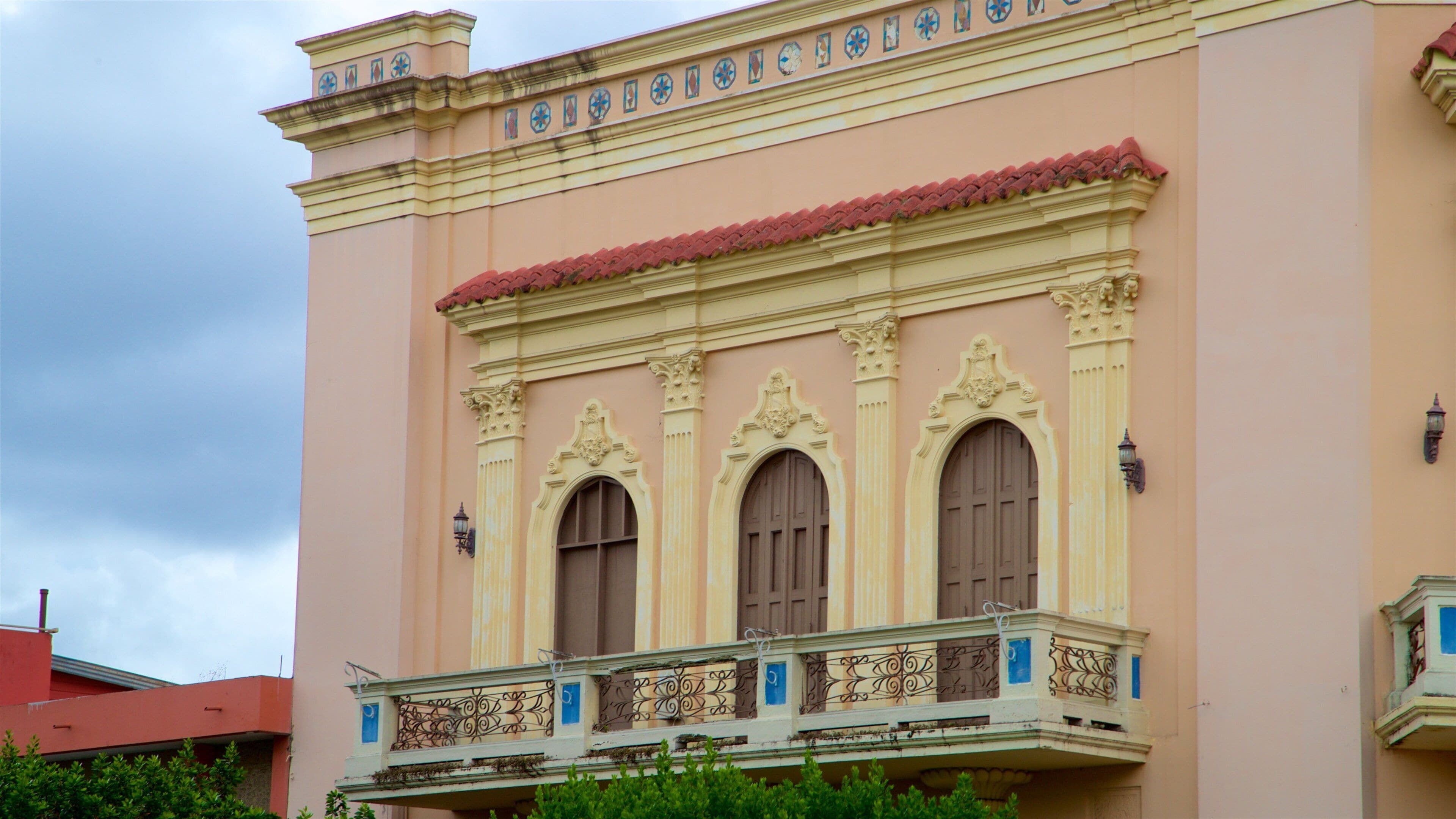 Un edificio rosa con balcones ornamentales y azulejos decorativos.