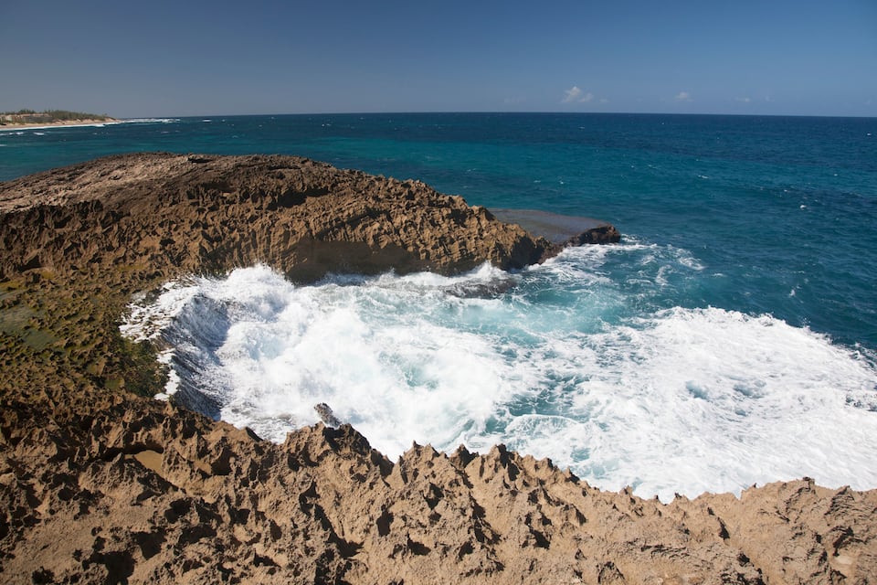 A rocky coastline with waves crashing against the shore.