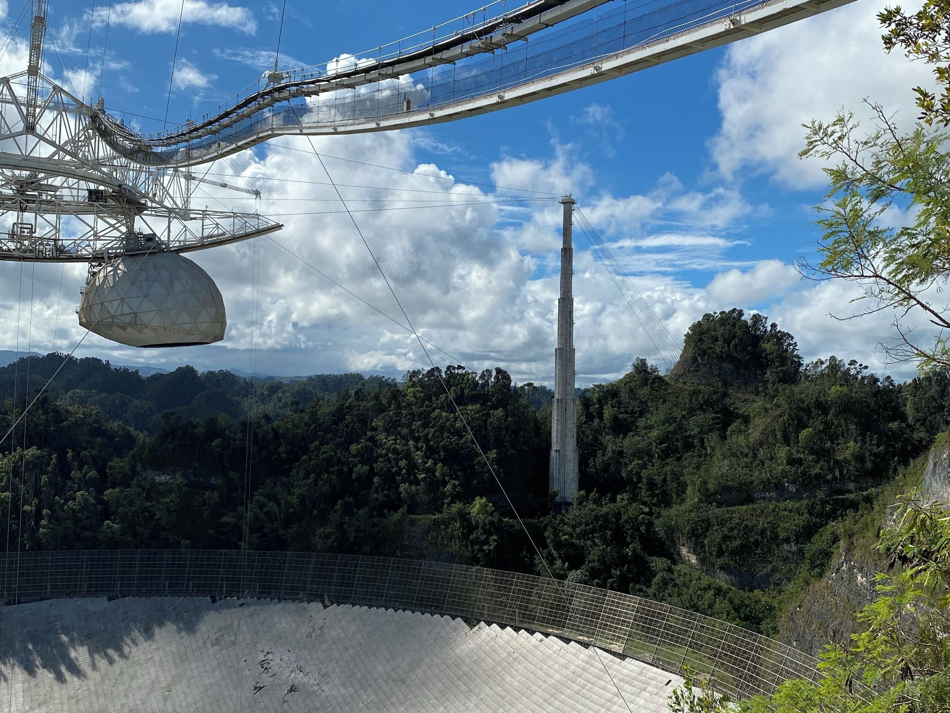 A cable car system, a large open-air amphitheater, and a forested mountain backdrop.