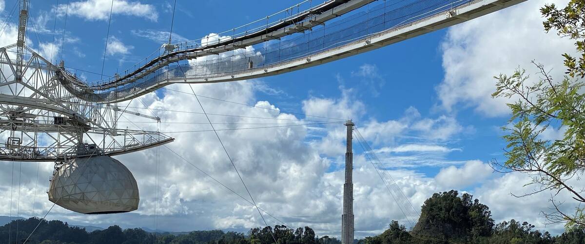 A cable car system, a large open-air amphitheater, and a forested mountain backdrop.