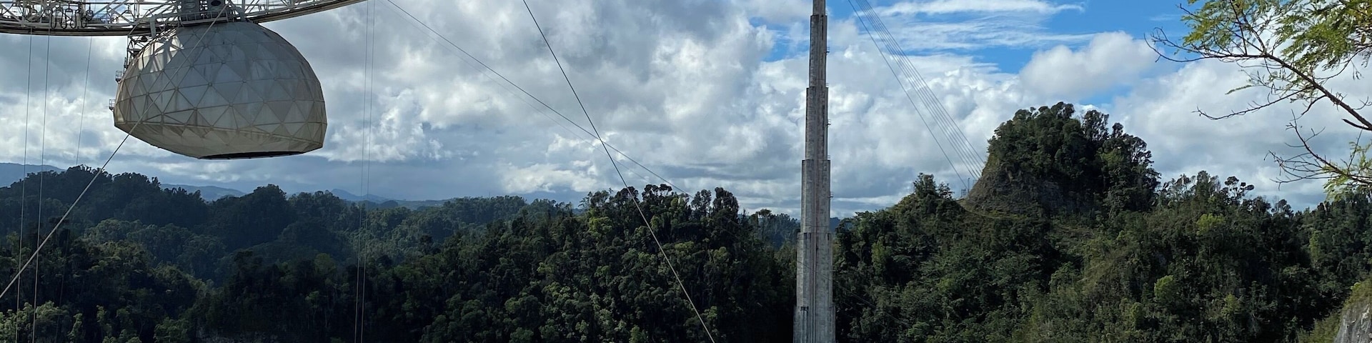 A cable car system, a large open-air amphitheater, and a forested mountain backdrop.