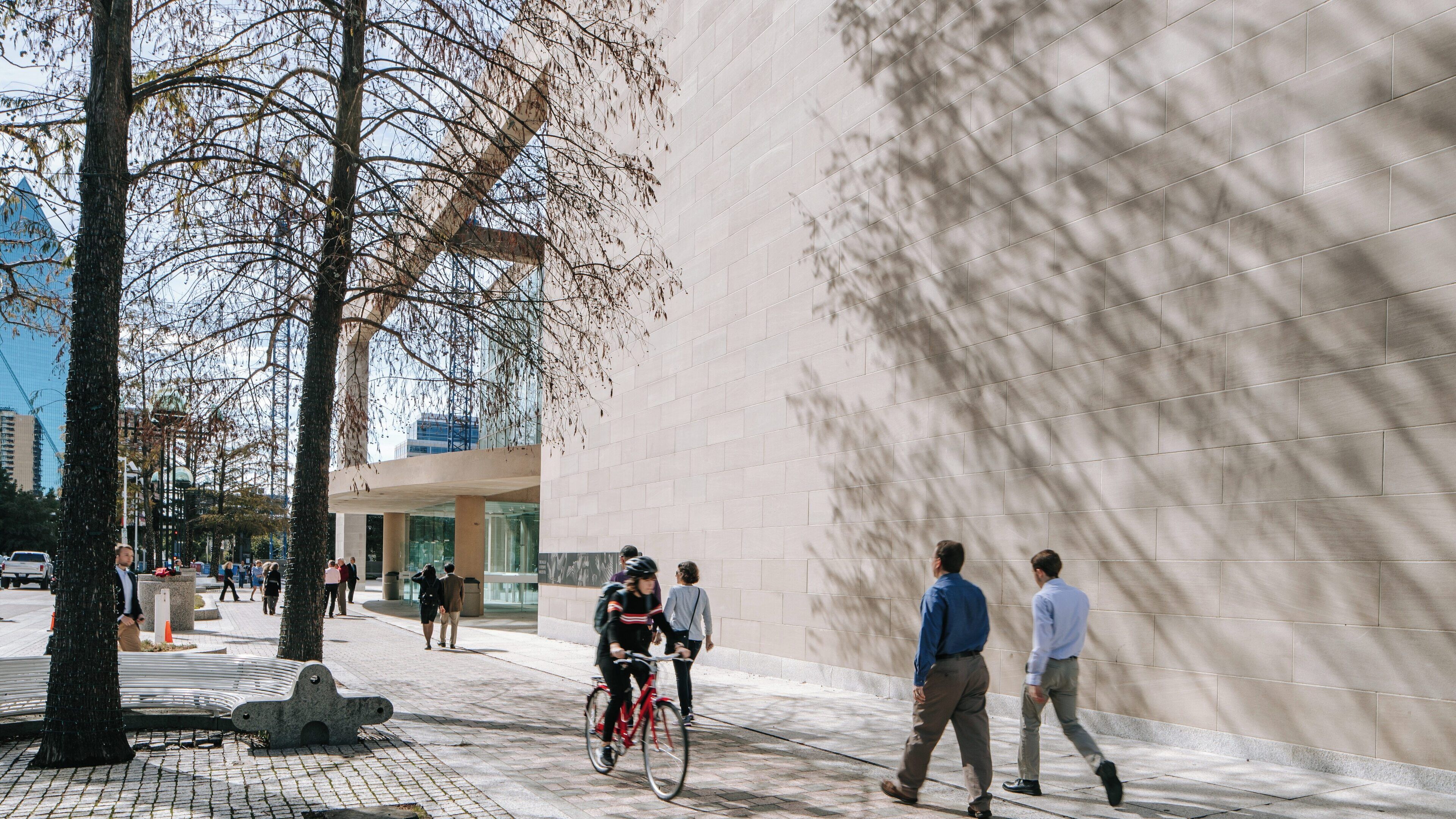 Morton H. Meyerson Symphony Center showcases vibrant activities in Dallas Arts District with pedestrians and cyclists enjoying the urban space