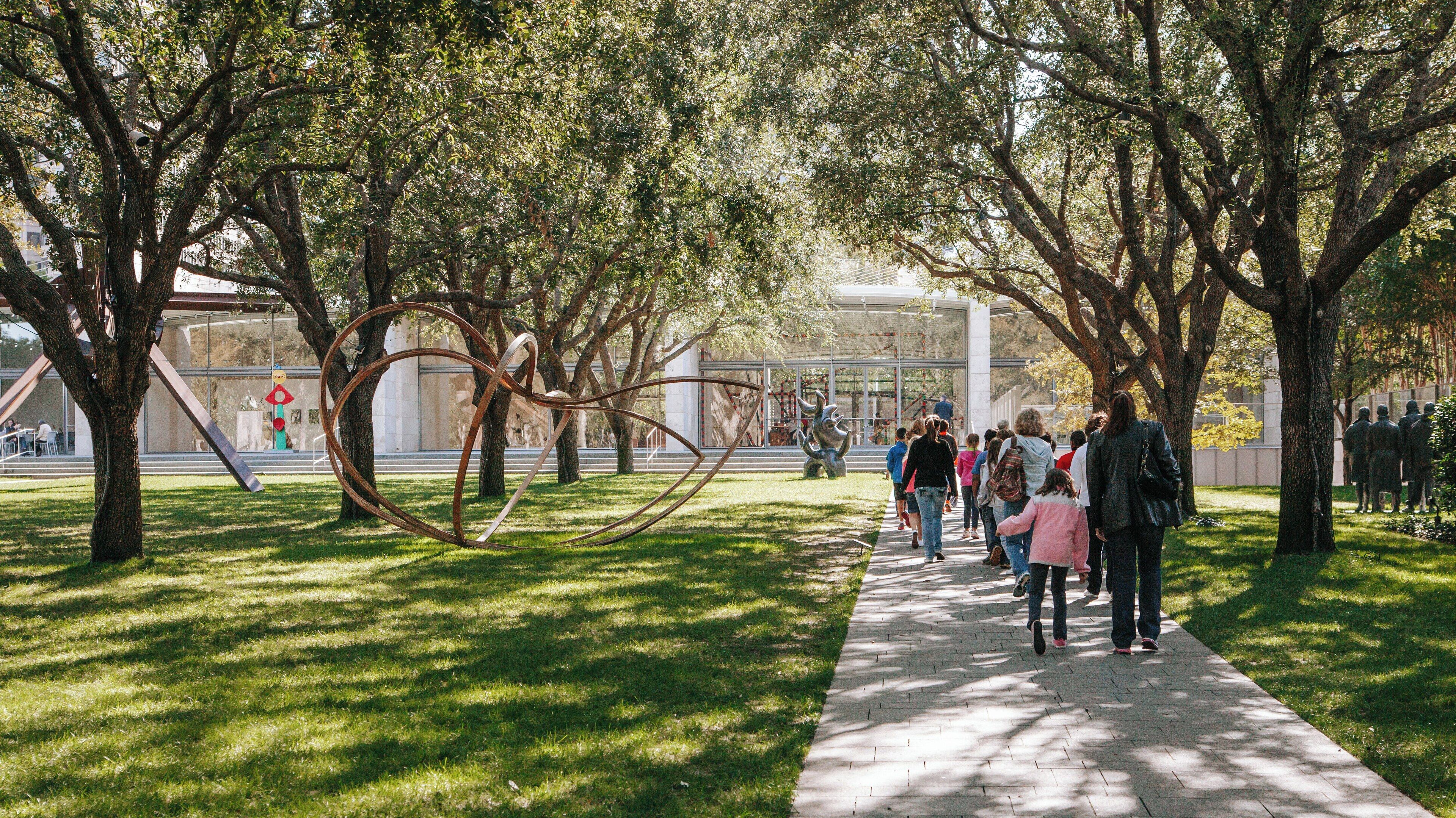 Visitors explore Nasher Sculpture Center in Dallas Arts District while enjoying contemporary art installations surrounded by greenery and sculptures