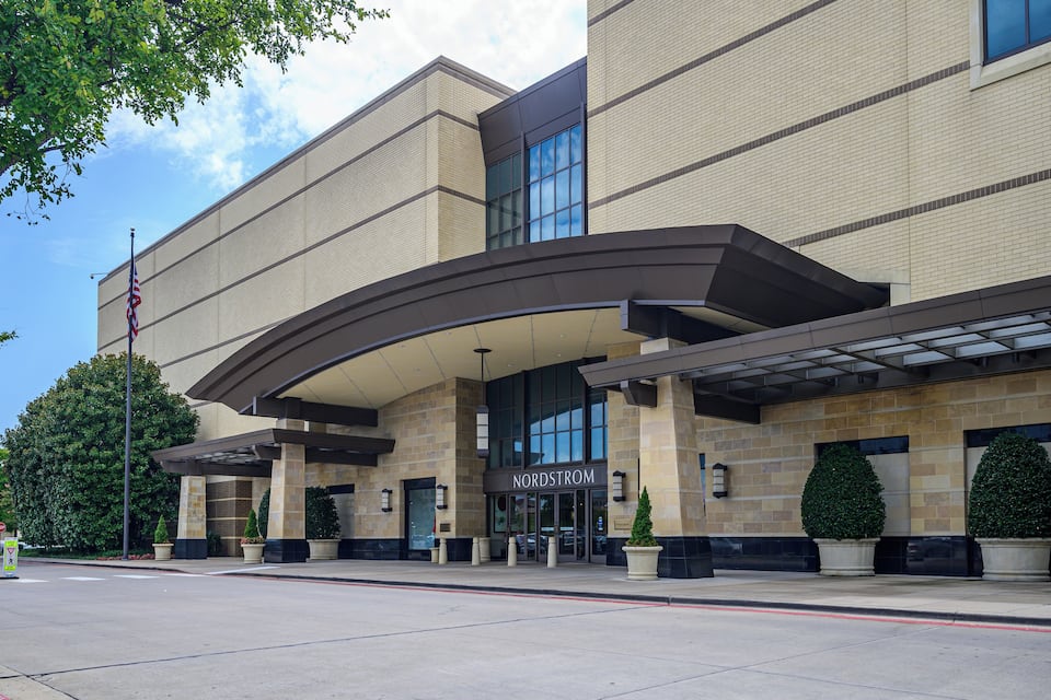 A modern building with a curved entrance, large windows, and a sign that reads "Nordstrom."
