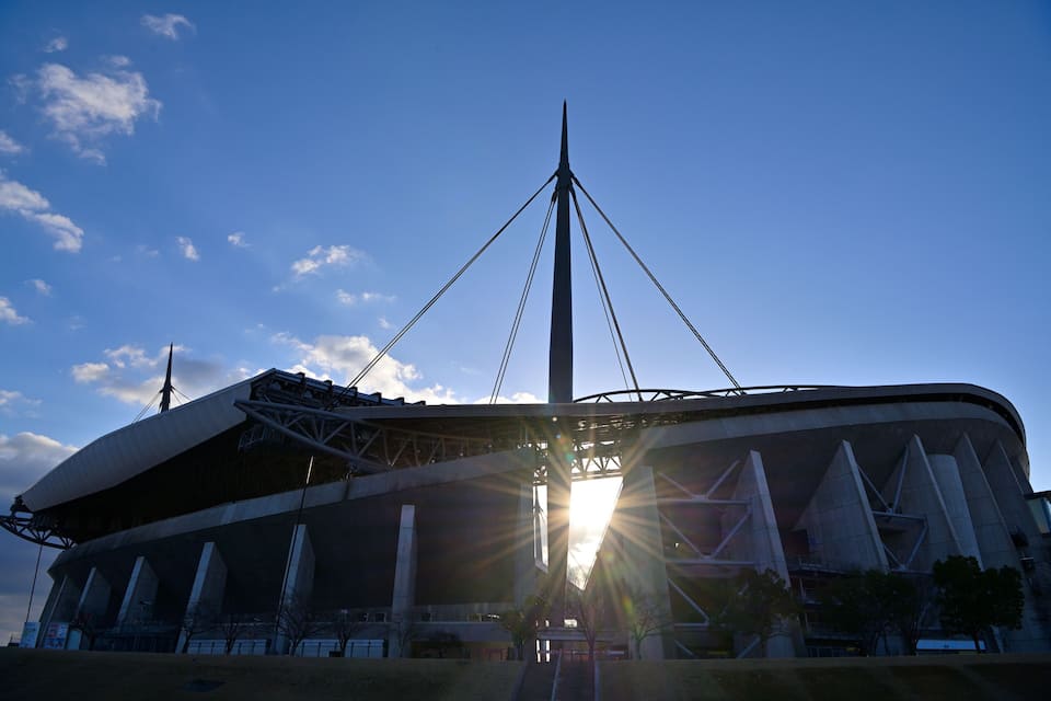 A stadium with a distinctive roof structure and a tall central tower.