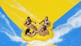 A group of people on a yellow raft at a water park.