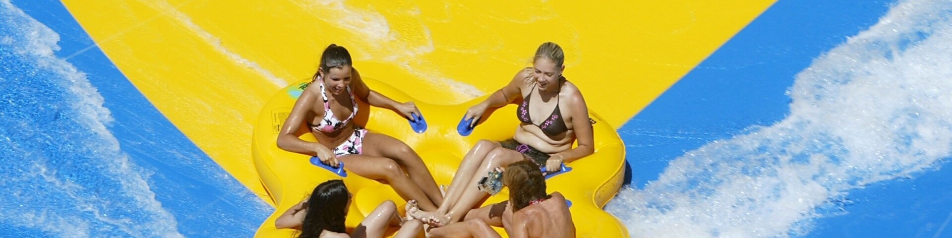 Un grupo de personas en un bote amarillo en un parque acuático.