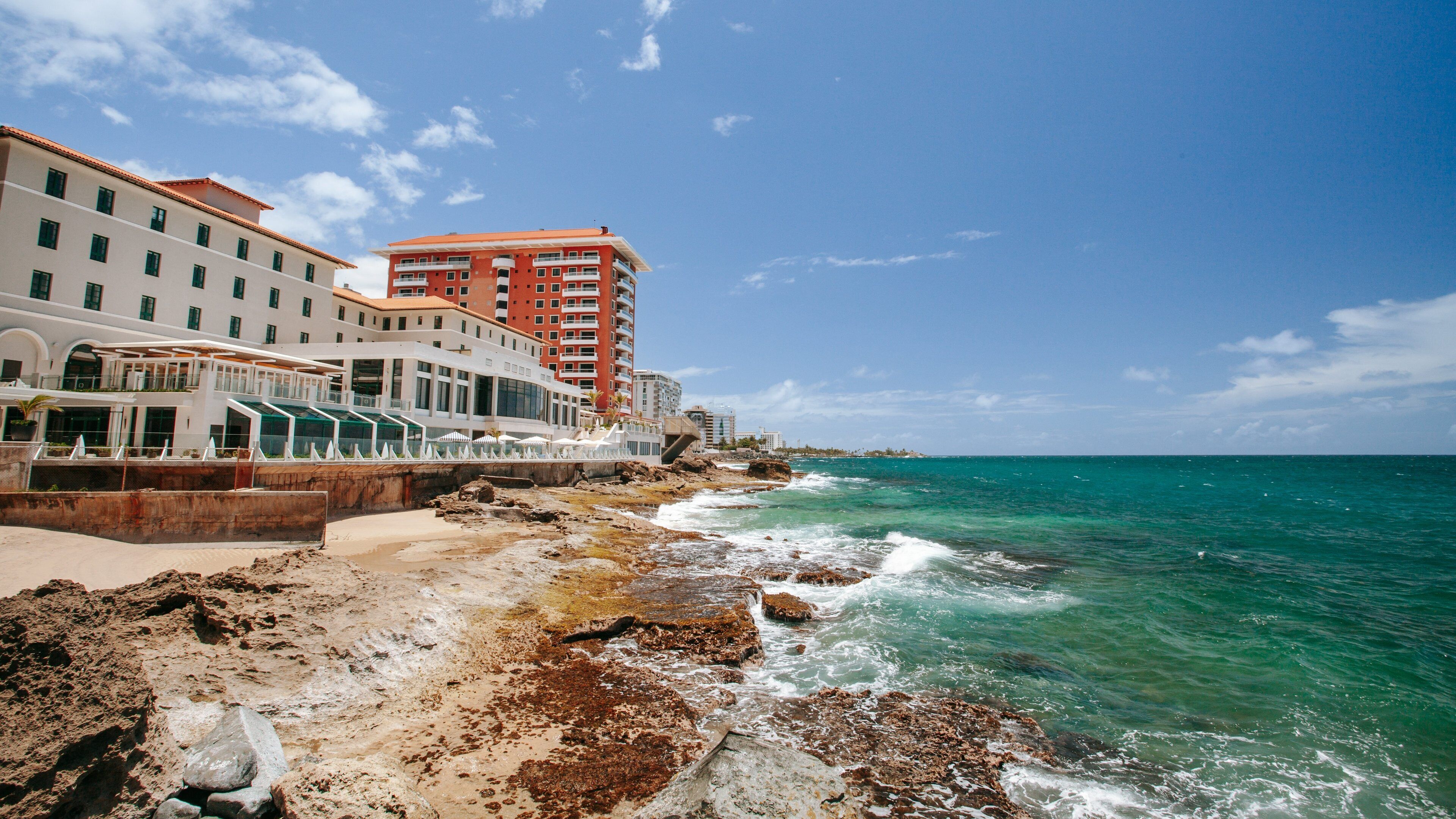 Condado Beach featuring general coastal views, a coastal town and rocky coastline