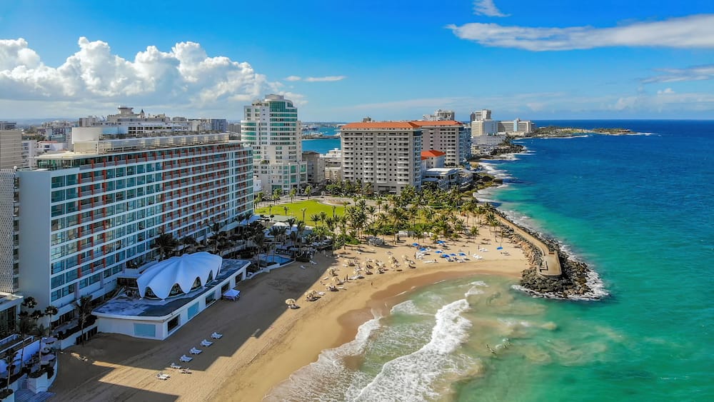Eine Küstenstadt mit Strand, hoch aufragenden Hotels und blauem Himmel.
