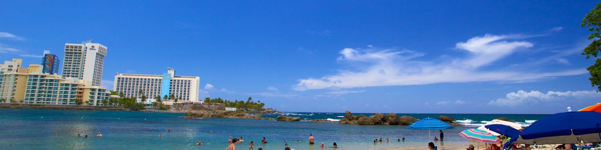 Condado Beach showing a sandy beach as well as a large group of people