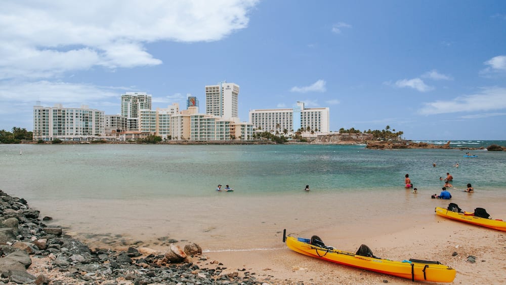 Condado Beach which includes a sandy beach, a coastal town and general coastal views