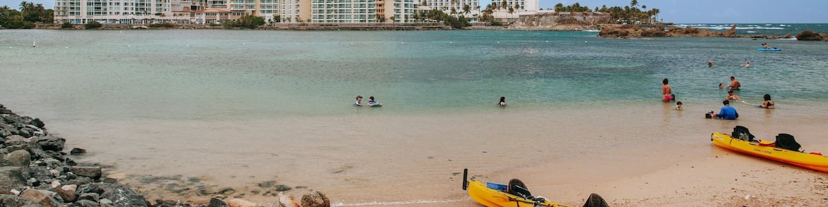 Condado Beach which includes a sandy beach, a coastal town and general coastal views