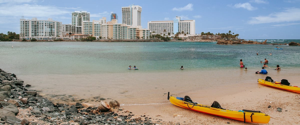 Condado Beach which includes a sandy beach, a coastal town and general coastal views