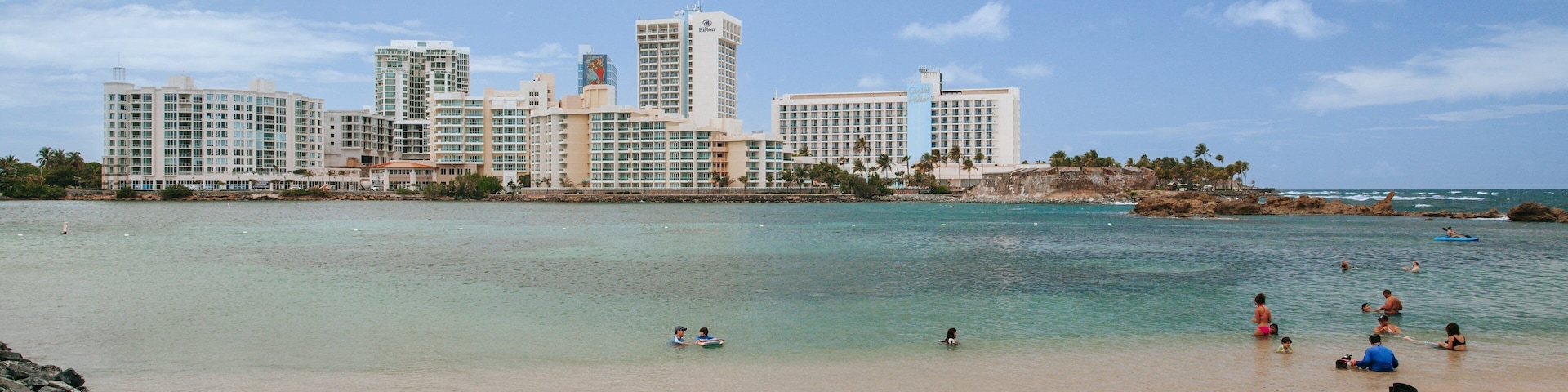 Condado Beach which includes a sandy beach, a coastal town and general coastal views
