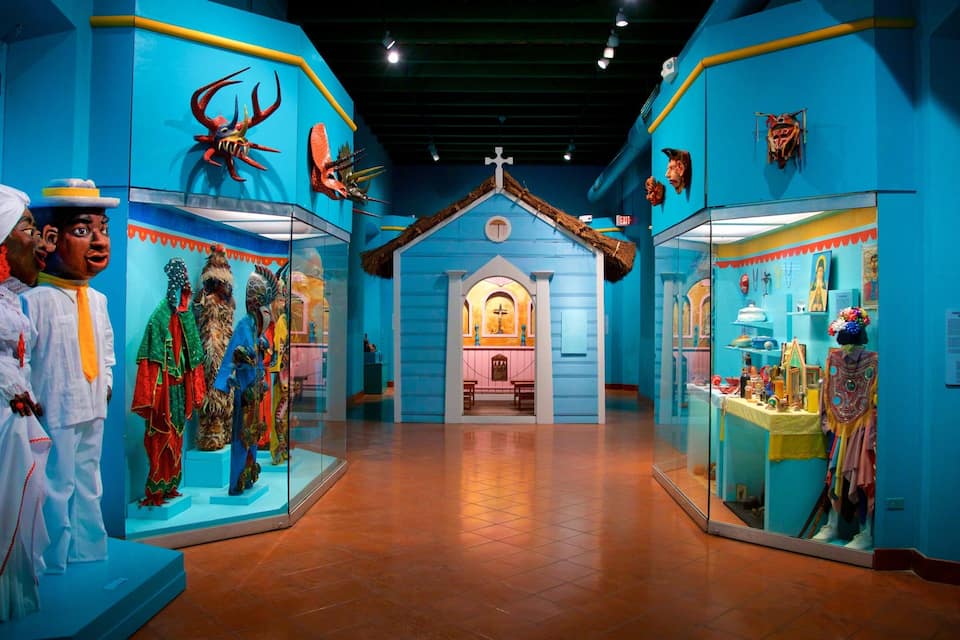 Uma exposição de museu com exposições coloridas e máscaras tradicionais.