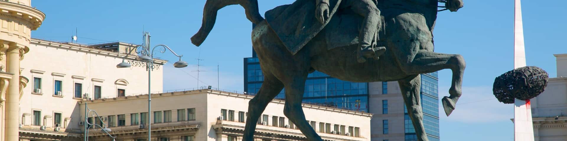 A statue of a man on a horse in an urban setting.