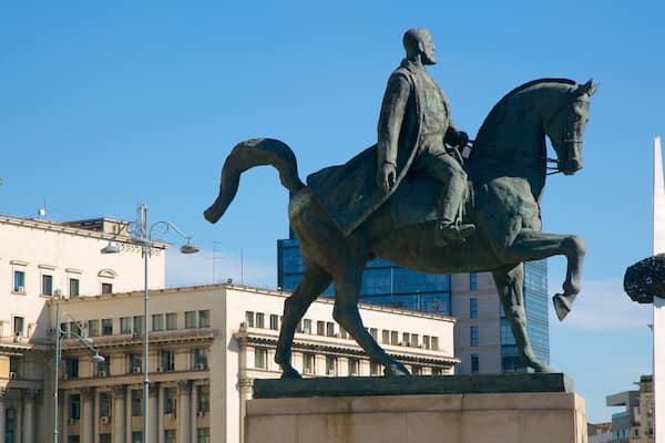 Estátua de um homem montado em um cavalo em área urbana.
