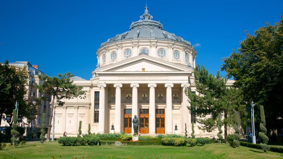 A classical building with a dome and columns, surrounded by well-maintained gardens and trees.