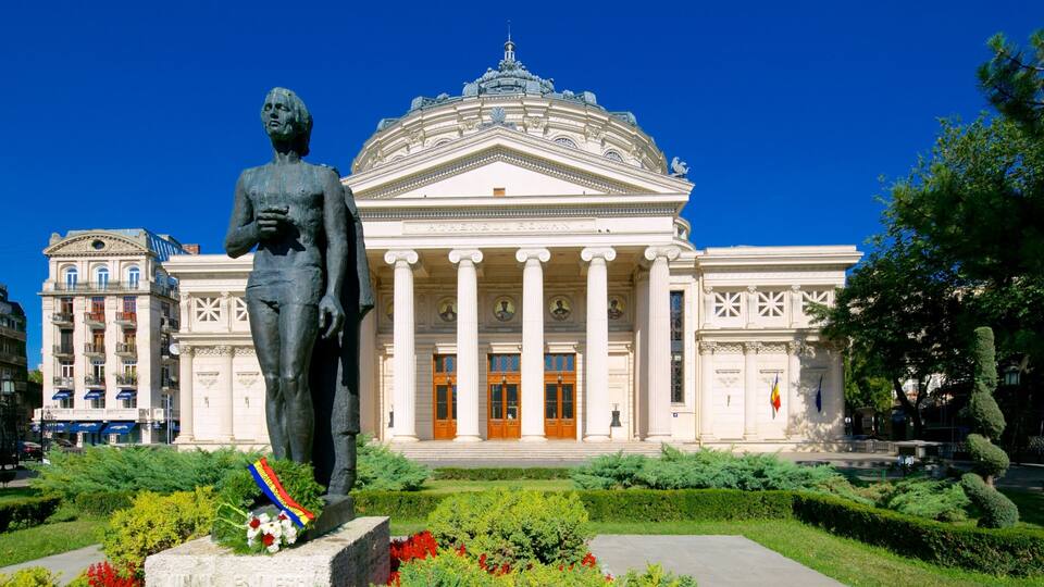 A classical building with columns and a statue in front.