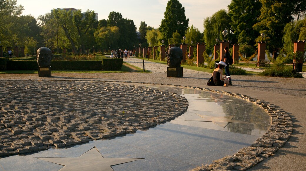 Herastrau Park which includes a garden, a fountain and a statue or sculpture