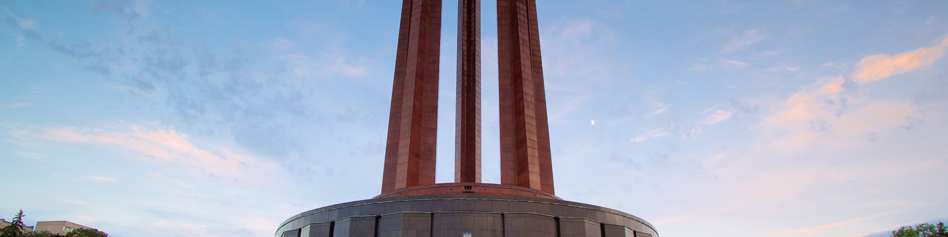 Carol Park showing a sunset and a monument as well as a small group of people