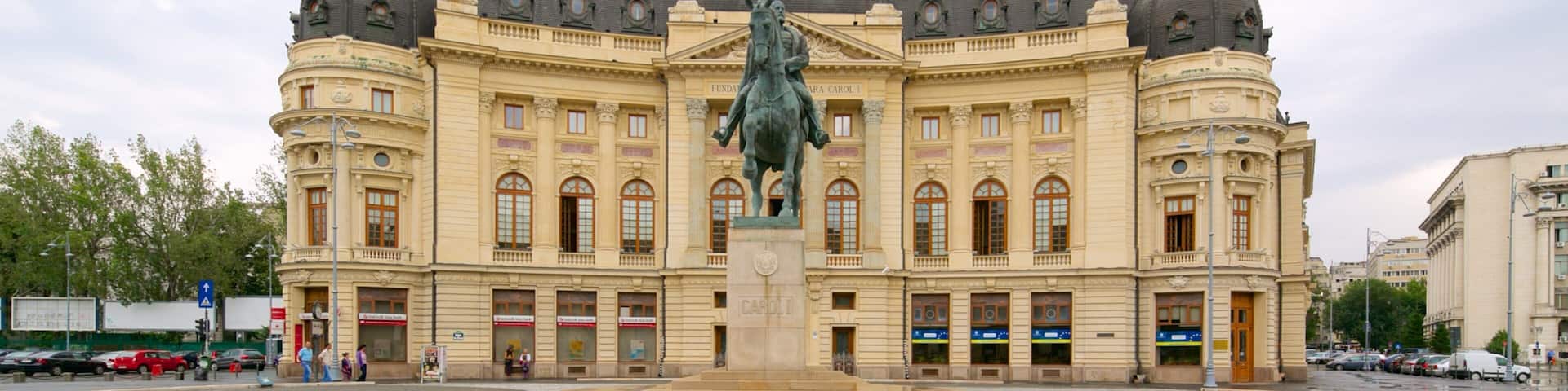A large, ornate building with domed roofs and a statue in front.