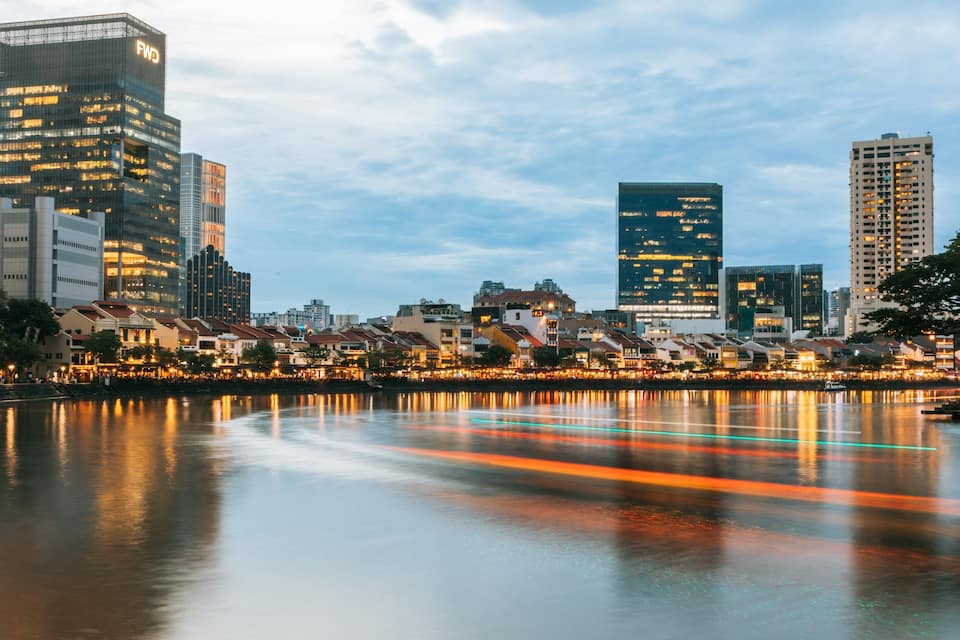 Un paisaje urbano con edificios modernos y un río que refleja luces.