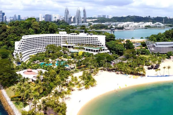 A coastal resort with a large hotel, a beach, and a marina.