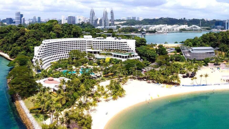 A coastal resort with a large hotel, a beach, and a marina.