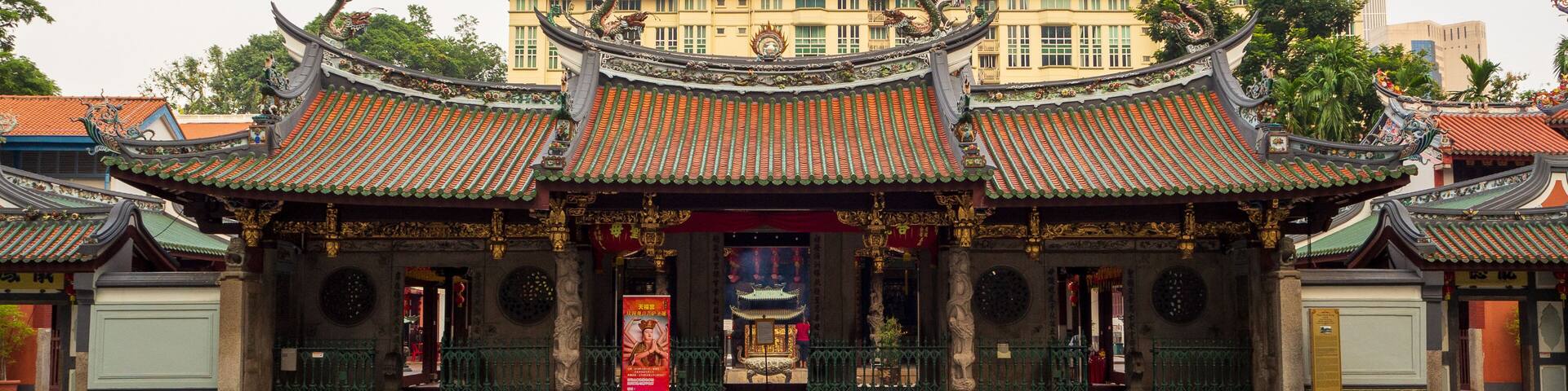 A traditional Chinese temple with ornate roofs and statues.