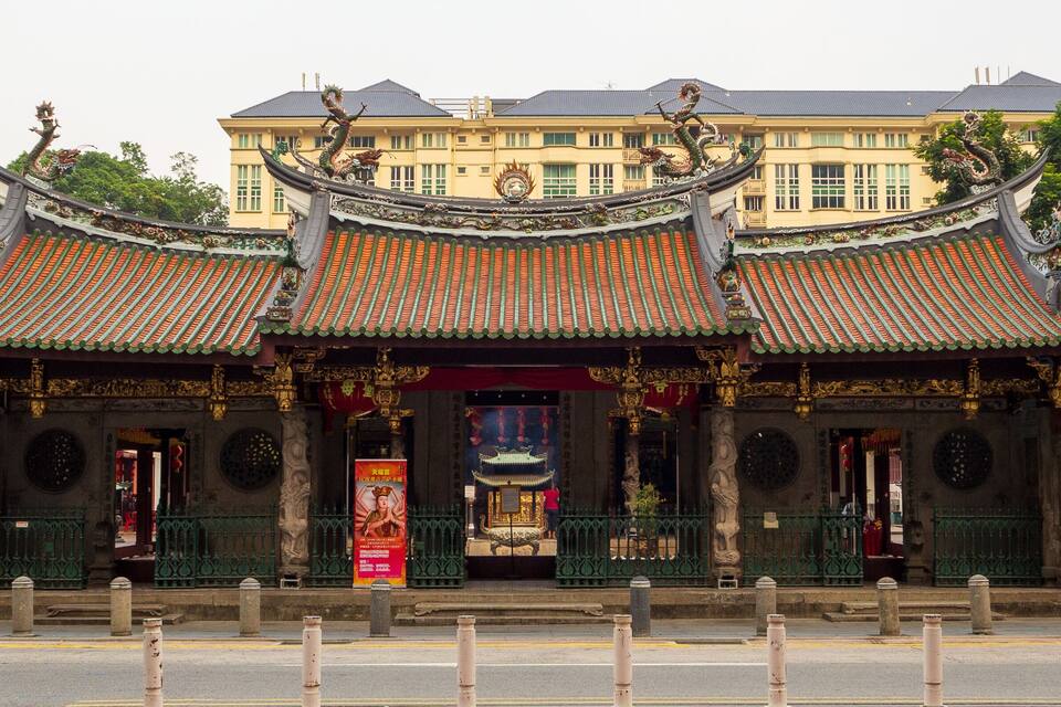 Un templo chino tradicional con techos ornamentados y estatuas.