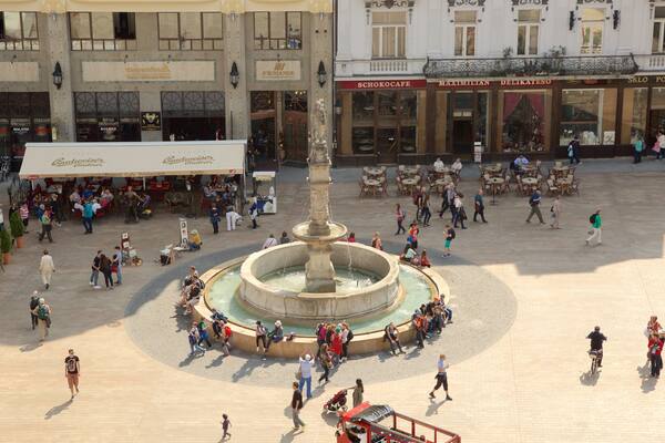 Hlavne-torget som inkluderar en fontÀn och ett torg sÄvÀl som en stor grupp av mÀnniskor