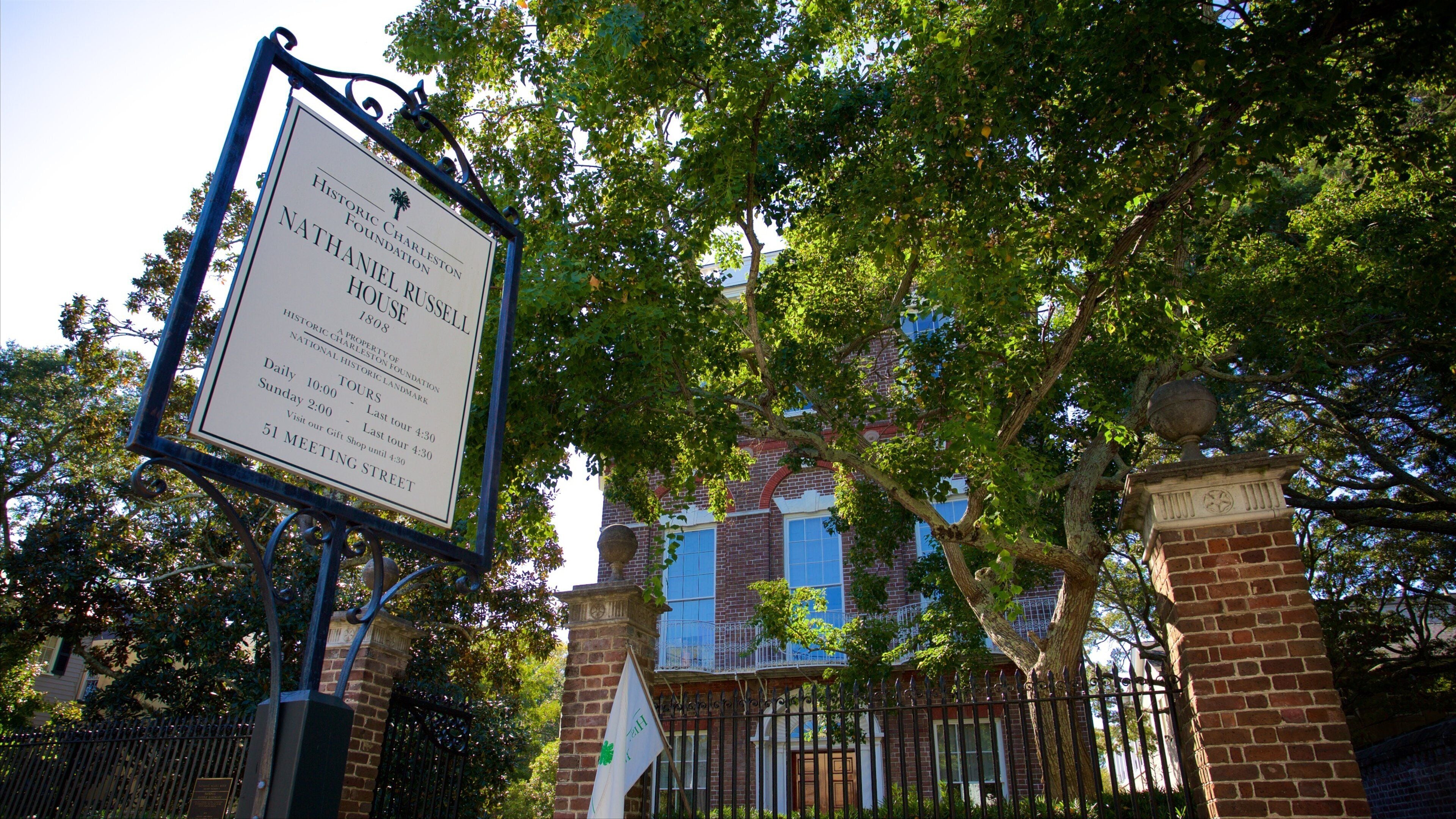 A historic marker sign for the Nathaniel Russell House, including tour times and meeting street information.