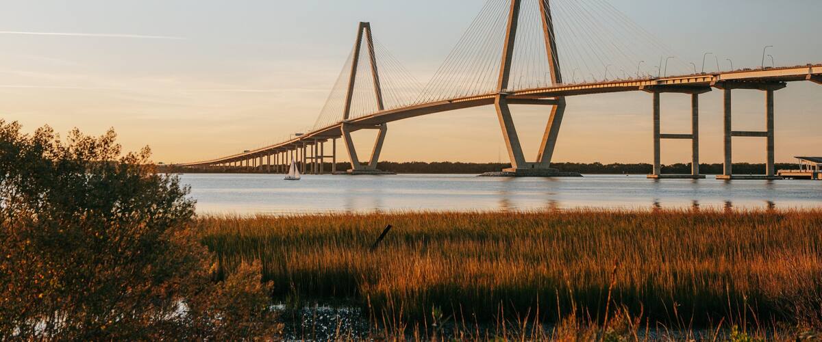 Arthur Ravenel Jr. Bridge showing a river or creek, landscape views and a sunset