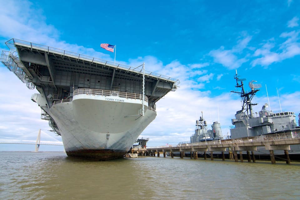 Un porte-avions nommé YORKTOWN était amarré à un quai, avec un pont en arrière-plan.