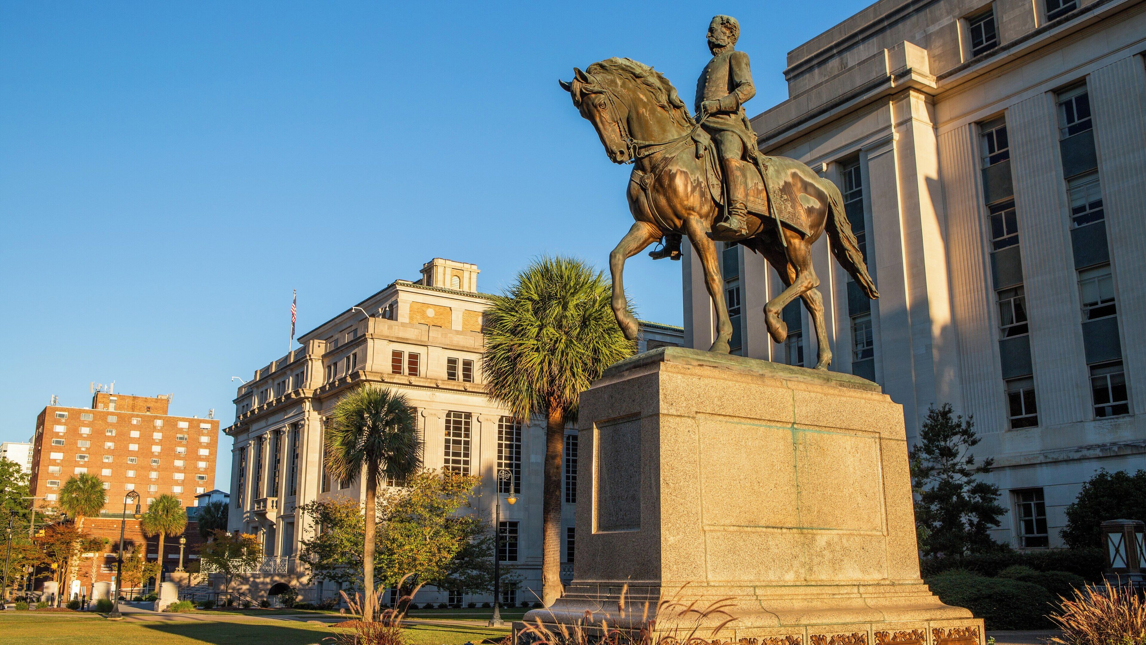View of the South Carolina State House with statue and palm trees in Downtown Columbia showcasing historic architecture