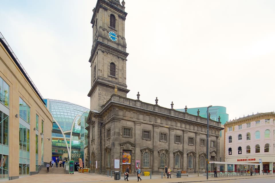 A historic building with a clock tower, modern glass structures, and a Burger King restaurant.