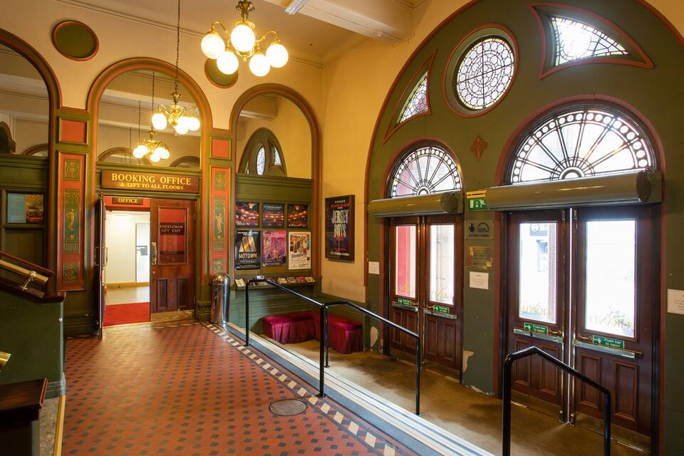 A grand interior with ornate arches, a booking office, and a lift to all floors.