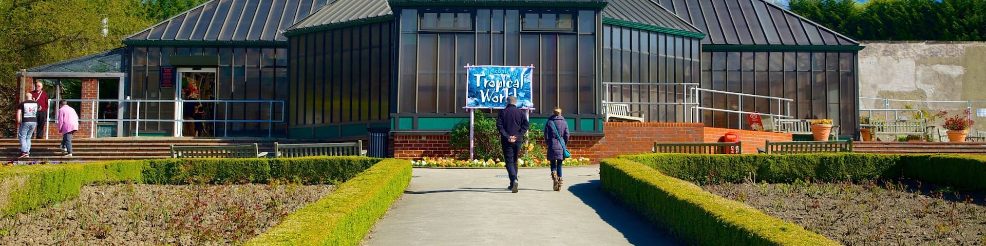 Tropical World featuring a park as well as a small group of people