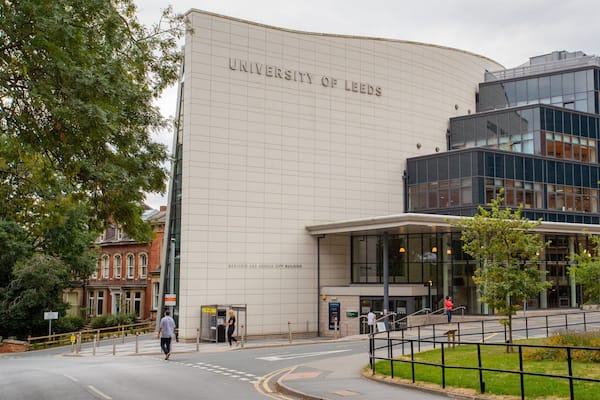 Das Gebäude der University of Leeds mit moderner Glasfassade und klassischem Backsteinstil.