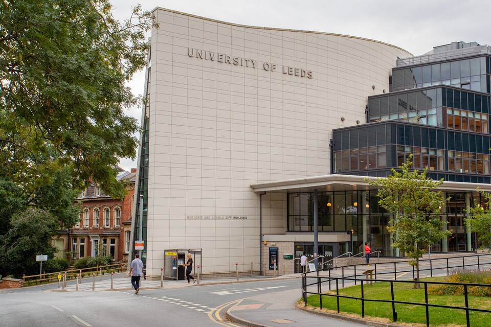 The University of Leeds building with a modern glass facade and a classical brick structure.