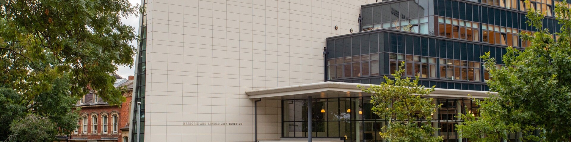 The University of Leeds building with a modern glass facade and a classical brick structure.