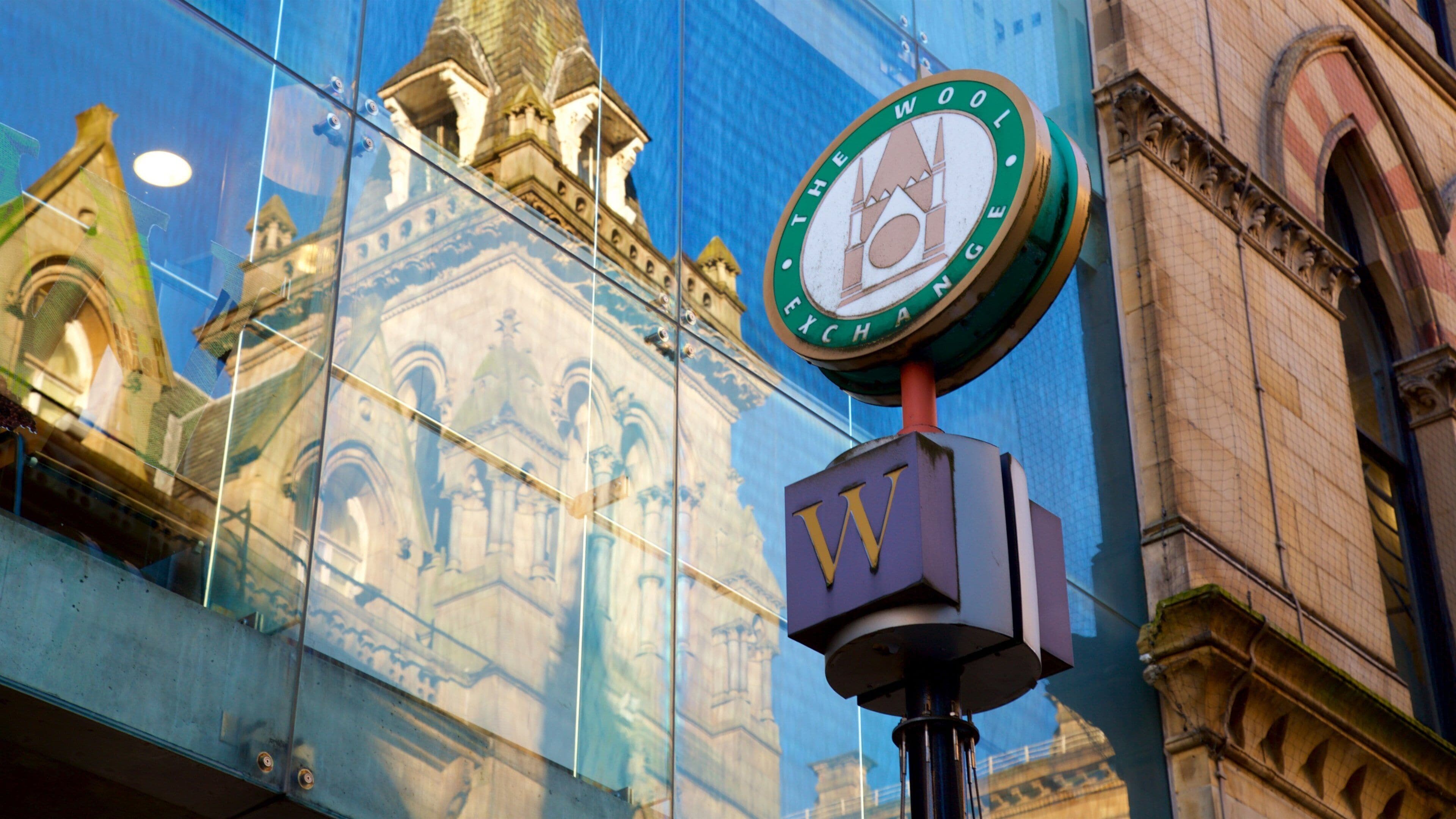 Un reloj con la inscripción 'Wool Exchange' en la fachada de un edificio.