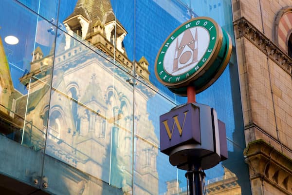 Une horloge portant l'inscription « Wool Exchange » sur la façade d'un immeuble.