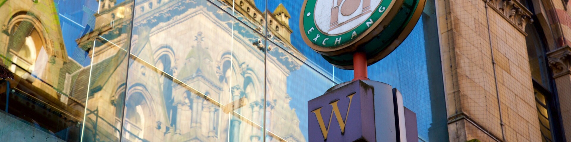 Um relógio na fachada de um edifício com a inscrição 'Wool Exchange'.