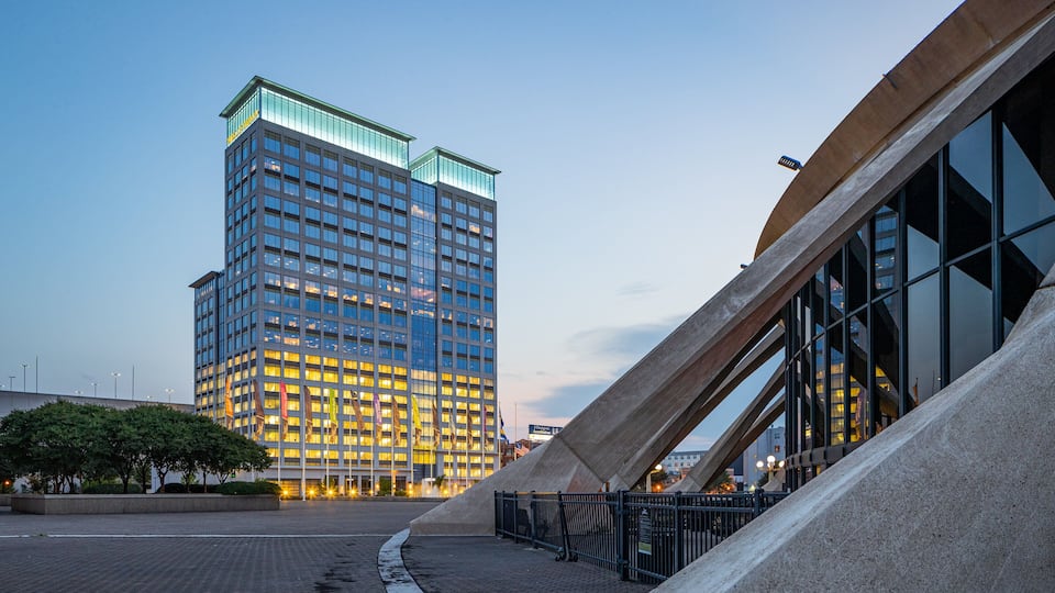 A modern building with glass windows and a unique curved structure.