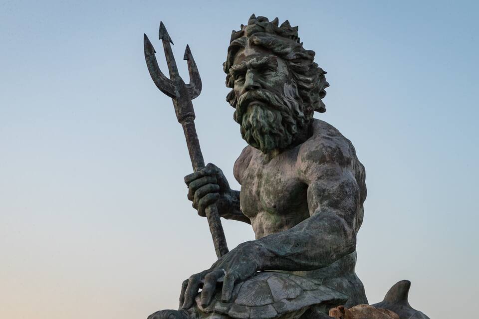 Una statua di un uomo barbuto che regge un tridente.