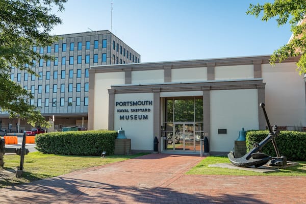 Un edificio identificado como Museo del Astillero Naval de Portsmouth, con un camino de ladrillo que conduce a la entrada.