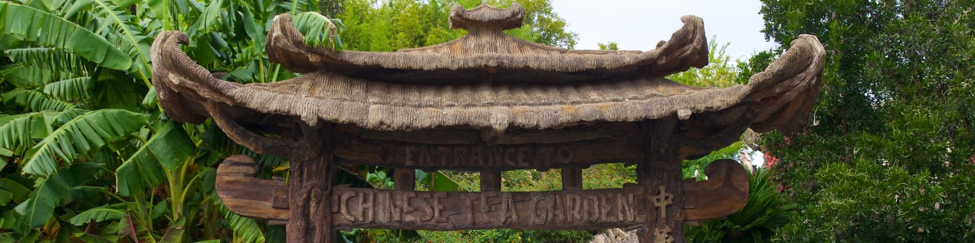 Une entrée typique d’un jardin de thé chinois, avec un escalier en pierre menant à une arche en bois.