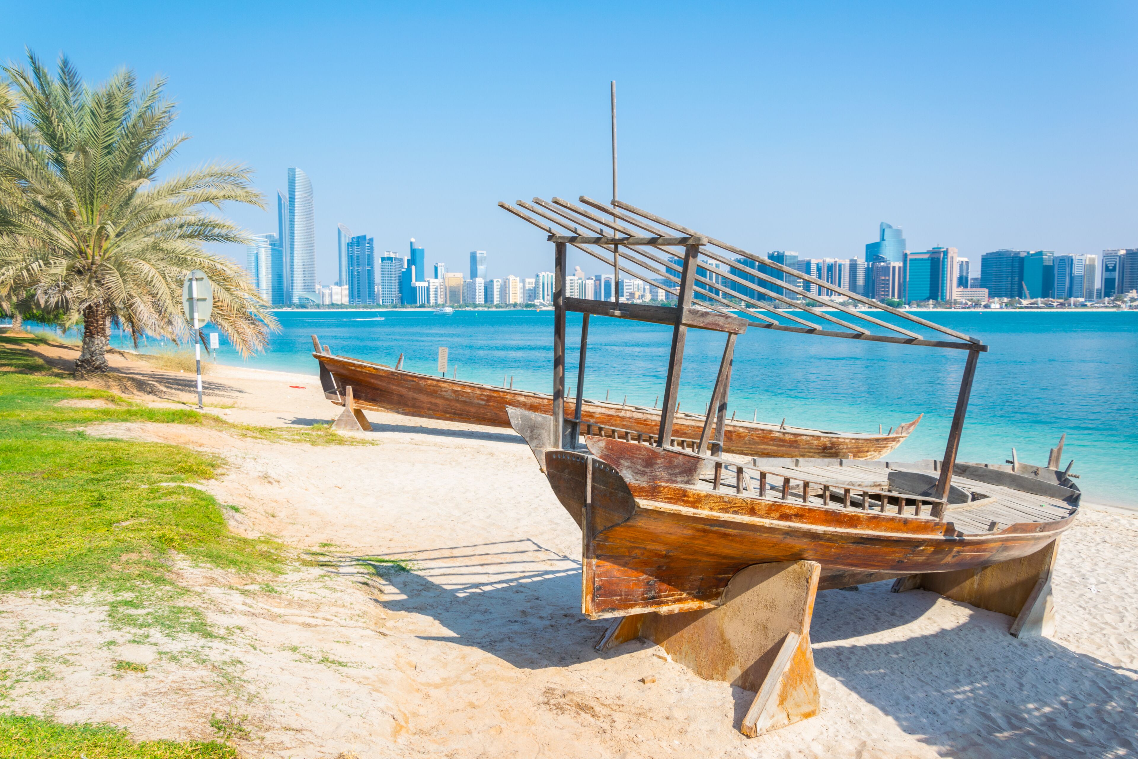 Wooden boat at the Heritage Village, in front of the Abu Dhabi skyline, United Arab Emirates